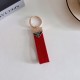 Prada Pebble Grain Leather Luxury Keychain - Signature Triangle Logo with Gold-Tone Hardware